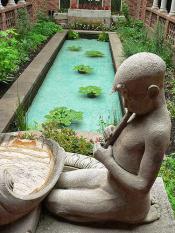 Statue of a young boy in the Reflection Garden at the Jordan Schnitzer Museum of Art at the University of Oregon (Flickr/Mary Harrsch).