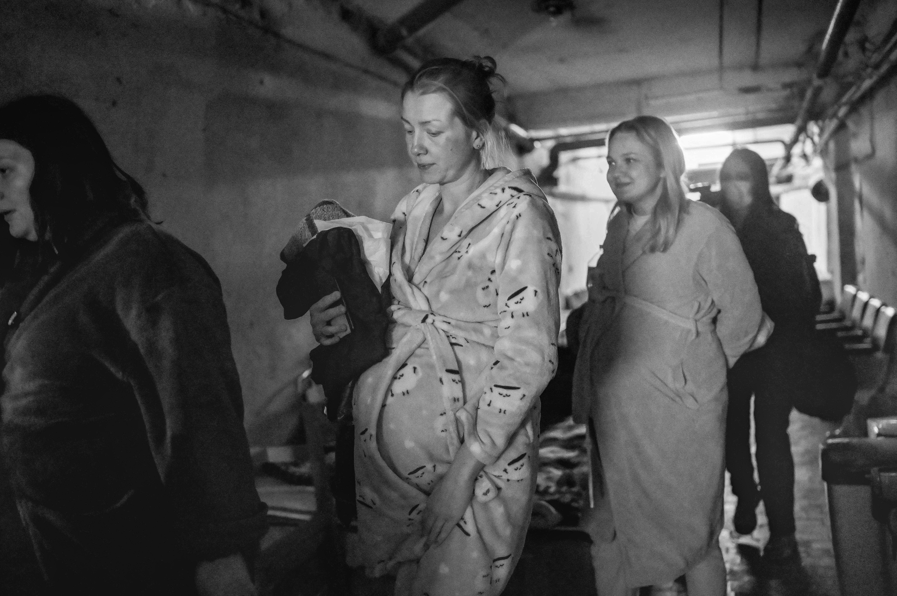 4 pregnant women dressed in robes, standing in line; grayscale