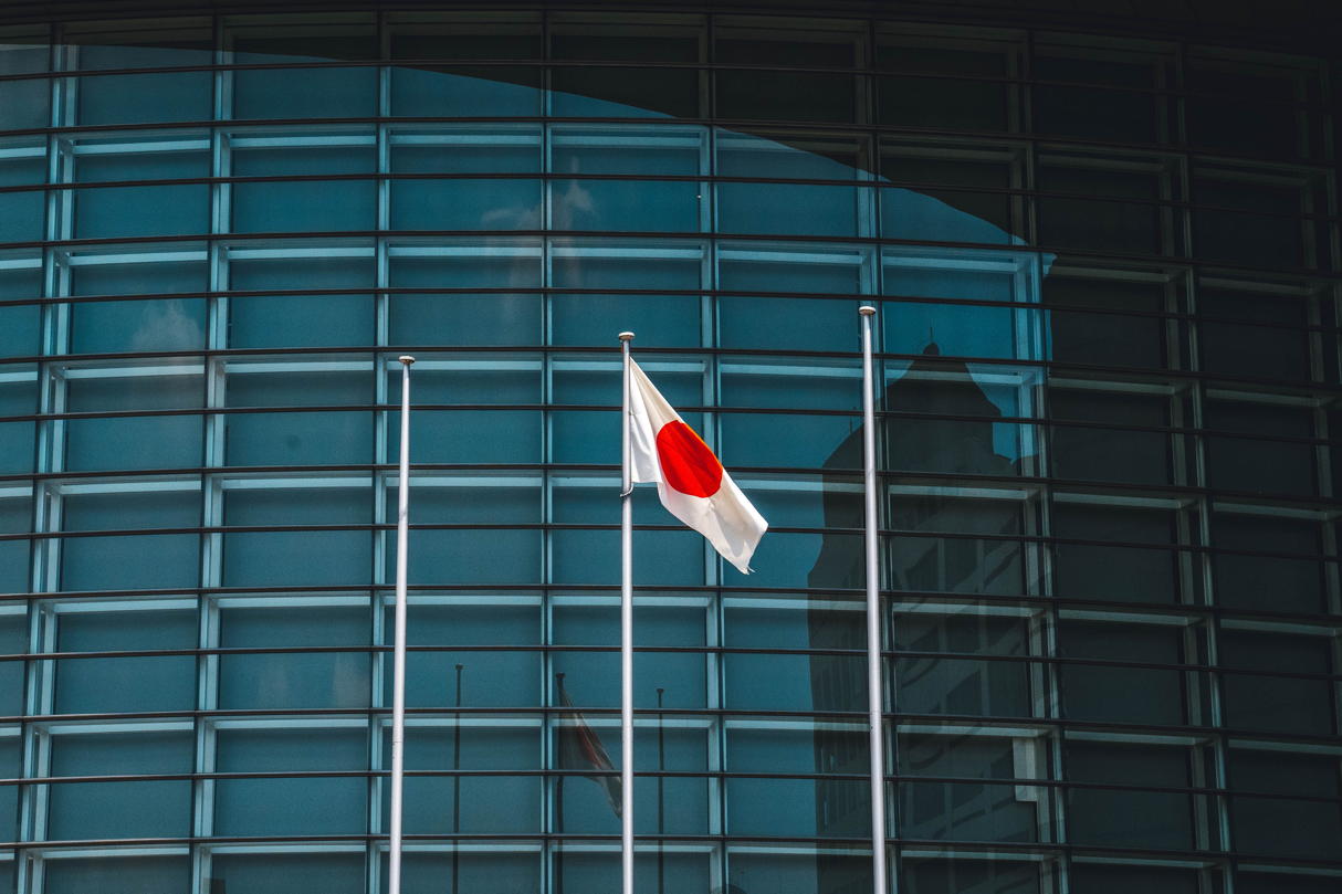 Japanese flag with blue building in background