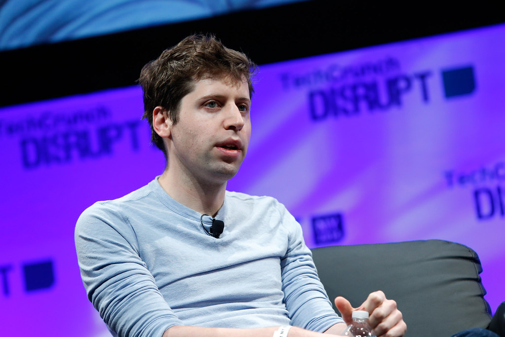 Image of Sam Altman speaking in front of a purple background