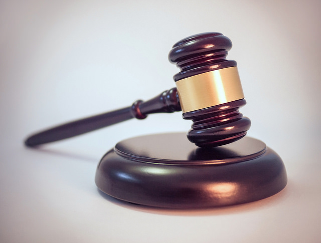 A gavel rests on a circular wooden stand.