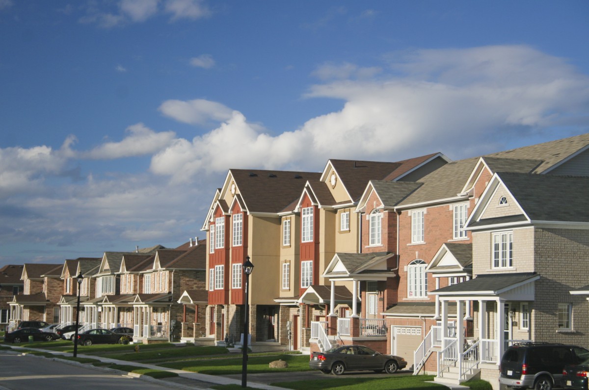 Suburban neighborhood on a sunny day with blue skies in the background.