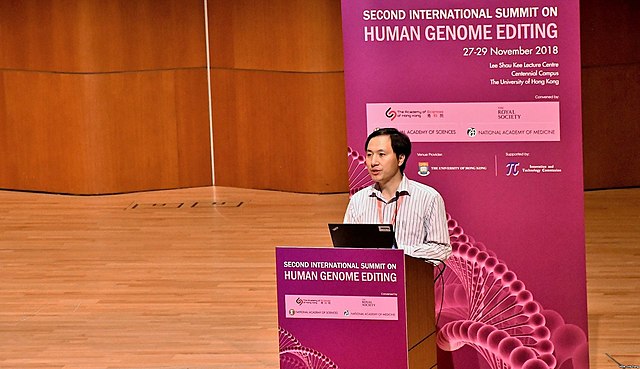 He Jiankui speaks at the podium at the Second International Summit on Human Genome Editing