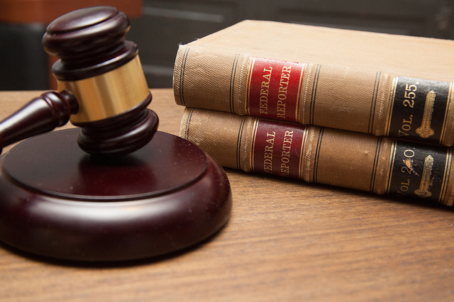 a gavel and two books on a wooden surface