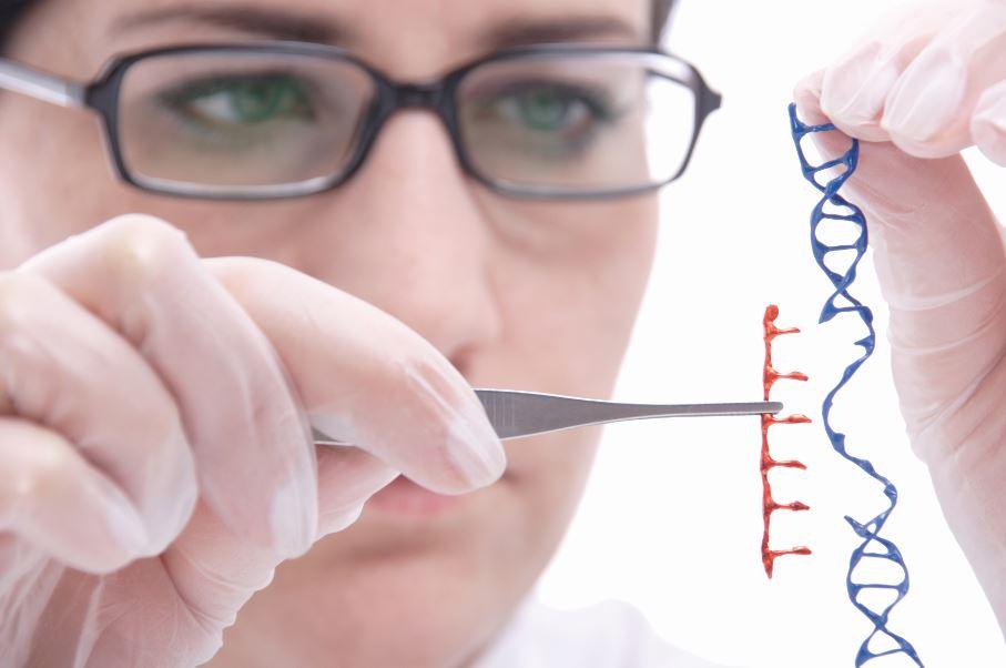 A scientist holds a strand of DNA and a tweezer tool.