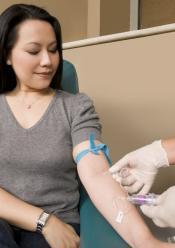 Doctor extracts blood from a patient.