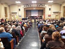 A public hearing is in session, angled as if the viewer was in the audience facing the representative officials.