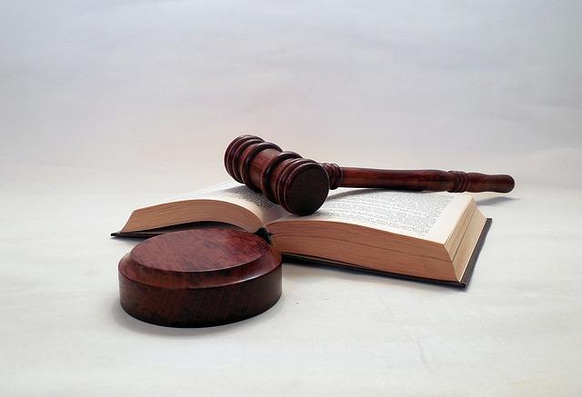 A book lies open, with a judge's gavel resting on top.