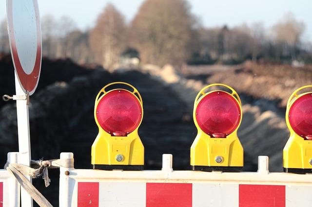 A road is blocked, with a barrier and lights.