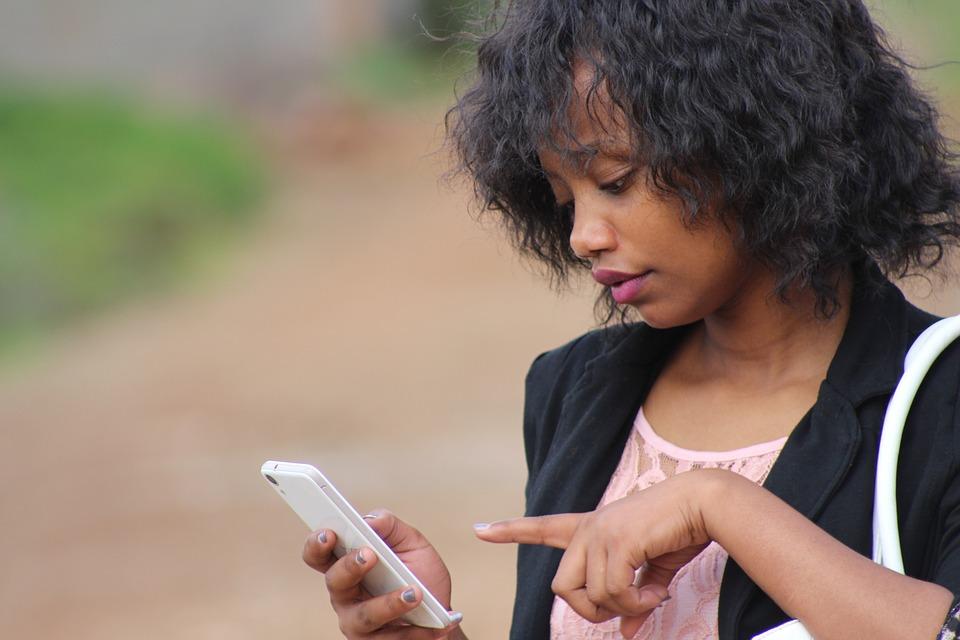 Woman looking and pointing at phone