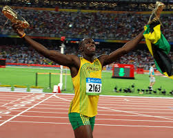 track star Usain Bolt holds up a flag after winning a race