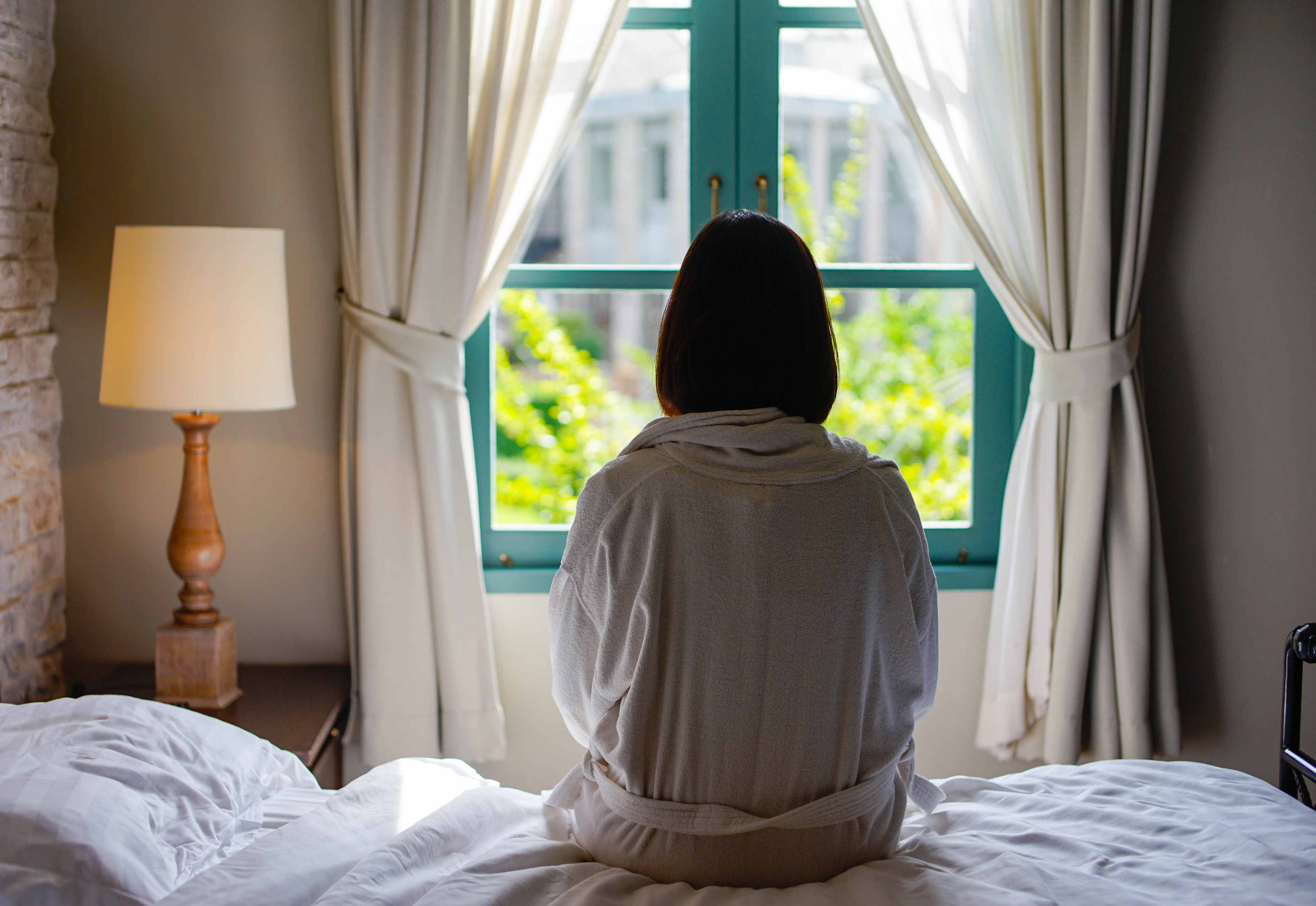 woman looking out of a window from behind